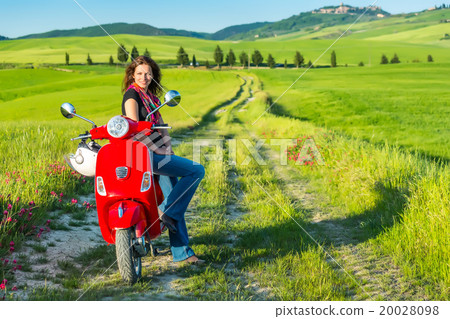 Young woman traveling by a scooter Young woman traveling by a scooter 20028098