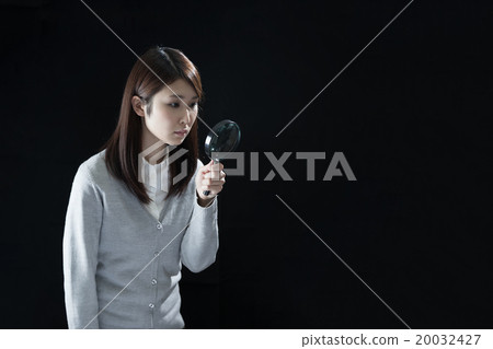 Woman looking through the magnifying glass 20032427