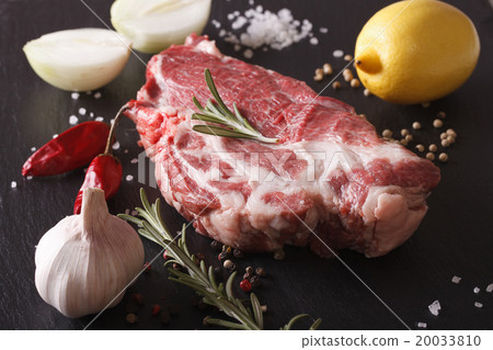 piece of raw pork neck and spices closeup on slate 20033810