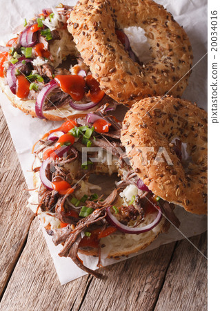 圖庫照片: bagels with pulled pork, onions and slaw close-up