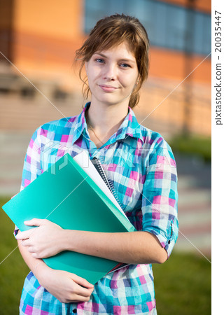 Portrait of young alluring woman holding education Portrait of young alluring woman holding education 20035447