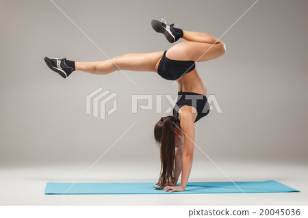 Beautiful sporty girl standing in acrobat pose or 20045036