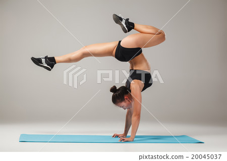 Beautiful sporty girl standing in acrobat pose or 20045037