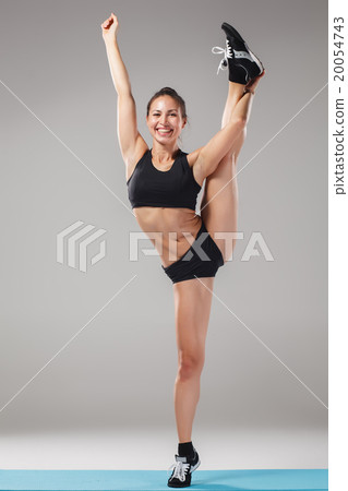 Beautiful sporty girl standing in acrobat pose or 20054743