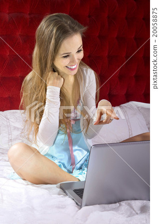 woman on bed with laptop 20058875