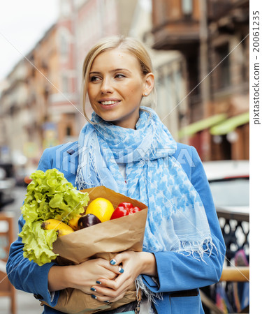 young pretty blond woman with food in bag walking 20061235