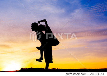 Piggyback boy and girl  silhouette during sun set. 20064141