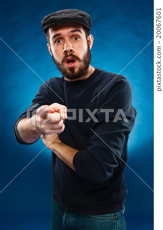 Young man in cap, finger pointing towards the 20067601