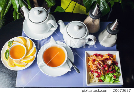 Honey with walnuts and cup of tea on purple Honey with walnuts and cup of tea on purple 20073657