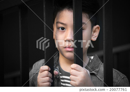 asian boy Hand in jail looking out the window 20077761
