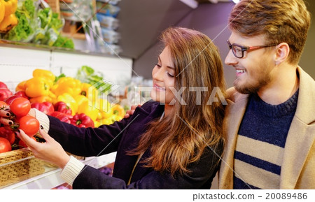 Couple choosing vegetables in a grocery store Couple choosing vegetables in a grocery store 20089486