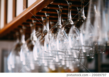 Empty glasses for wine above a bar rack. Hanging Empty glasses for wine above a bar rack. Hanging 20089797