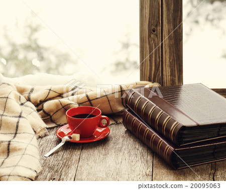 Red cup of coffee or tea on wooden windowsill. 20095063