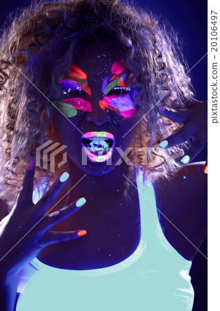 Portrait of curly girl with ice cube in UV light 20106497
