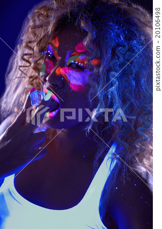 Beautiful curly girl posing in ultraviolet light Beautiful curly girl posing in ultraviolet light 20106498