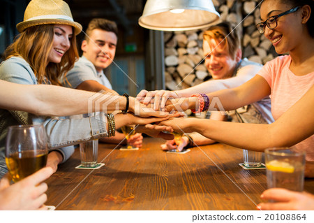 friends putting hands on top of each other at bar 20108864