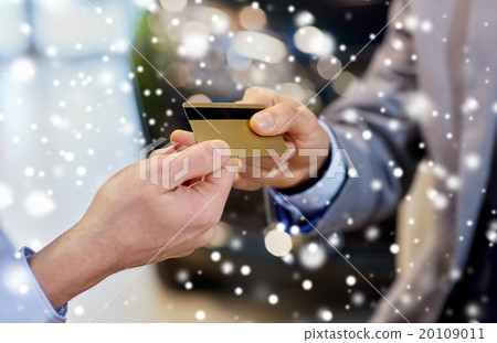 customer giving credit card to car dealer in salon 20109011