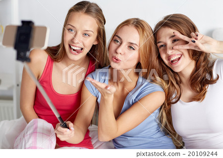 teen girls with smartphone taking selfie at home 20109244
