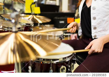 close up of woman playing cymbals at music store 20109383