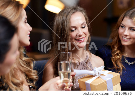 happy women with champagne and gift at night club 20109686