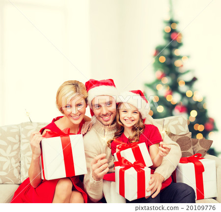 smiling family holding gift boxes and sparkles 20109776