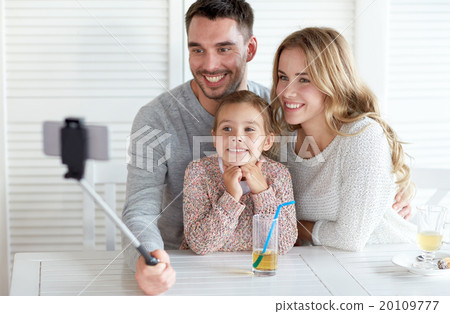 happy family taking selfie at restaurant 20109777