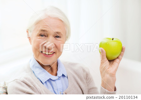 happy senior woman with green apple at home happy senior woman with green apple at home 20110134