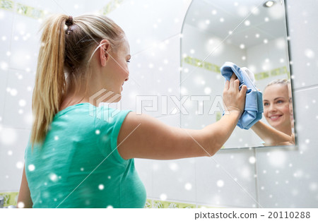 happy woman cleaning mirror with rag 20110288