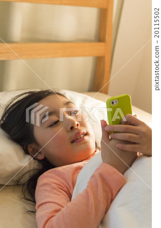 A girl watching a smartphone in bed 20115502