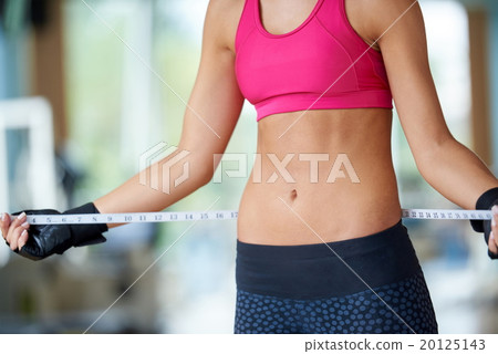 young fit woman measuring belly 20125143