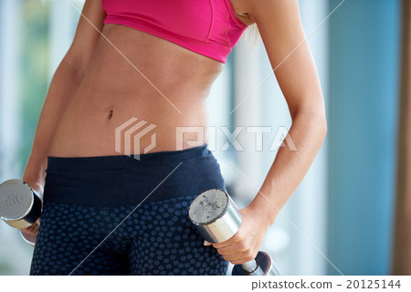 lifting some weights and working on her biceps in a gym 20125144