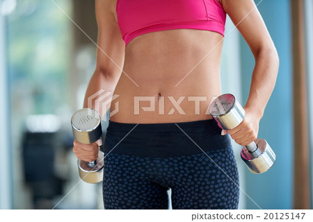 lifting some weights and working on her biceps in a gym 20125147