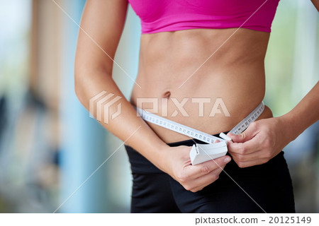 young fit woman measuring belly 20125149