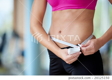 young fit woman measuring belly 20125150