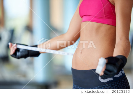 young fit woman measuring belly 20125153