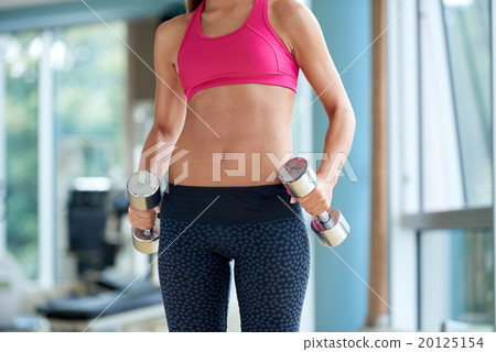lifting some weights and working on her biceps in a gym 20125154