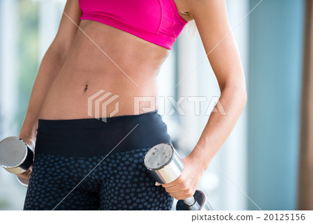 lifting some weights and working on her biceps in a gym 20125156