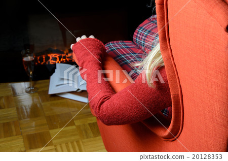 Lady enjoying by the fireplace Lady enjoying by the fireplace 20128353
