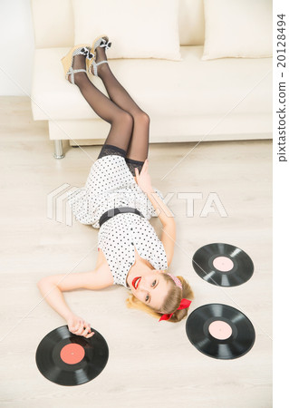Young attractive girl among vinyl recordings. Young attractive girl among vinyl recordings. 20128494