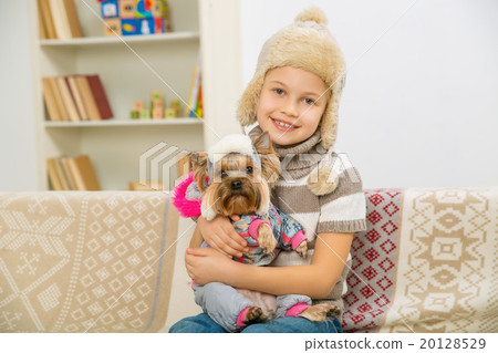 Little girl and her pet dressed in warm clothes.  20128529