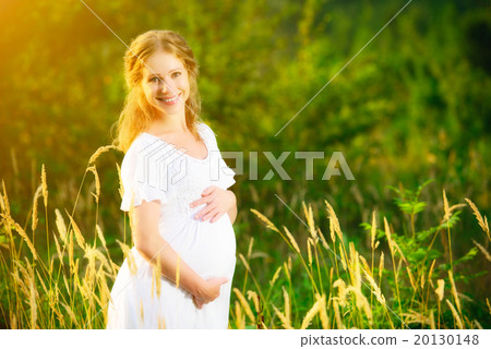 beautiful pregnant woman in summer nature meadow in sunset beautiful pregnant woman in summer nature meadow in sunset 20130148