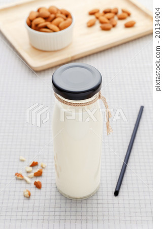 Almond milk in bottle with almonds on table Almond milk in bottle with almonds on table 20134904