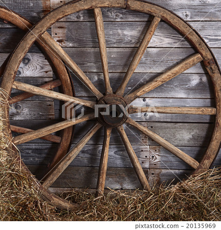Old wooden wheel on a hay 20135969