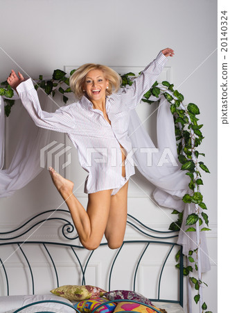 young woman jumping on the bed 20140324