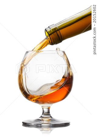 Cognac pouring into glass with splash isolated on 20152602