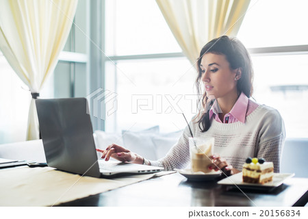 Woman working on laptop notebook computer at cafe 20156834