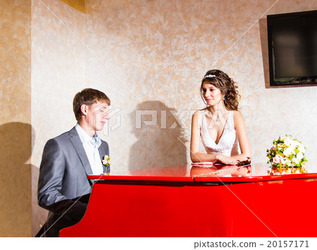 charming wedding couple playing on a red piano in charming wedding couple playing on a red piano in 20157171