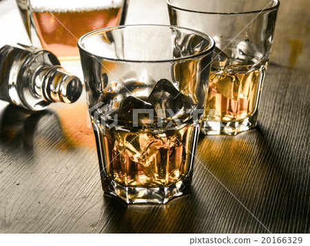 Whiskey on the rocks on a wooden table Whiskey on the rocks on a wooden table 20166329