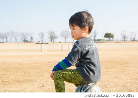 A boy sitting on a soccer ball A boy sitting on a soccer ball 20166882