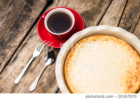 Baked cheesecake in cake pan with cup of tea 20167070
